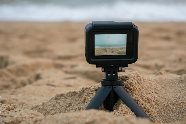 Caméra d'action compacte capturant une scène de plage isolée sur le fond extérieur