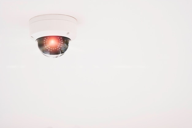 Caméra CCTV moderne pour surveiller la surveillance et la sécurité sur le plafond blanc.