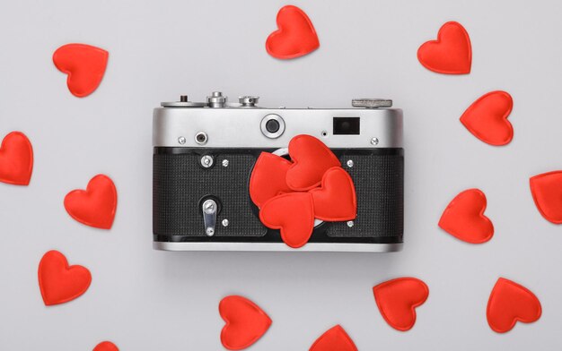 Caméra rétro avec des cœurs rouges sur un fond gris Concept de la Saint-Valentin