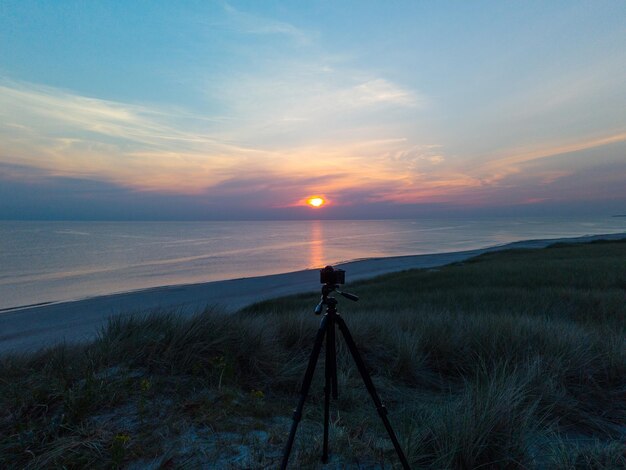 Caméra sur trépied enregistrant le coucher du soleil