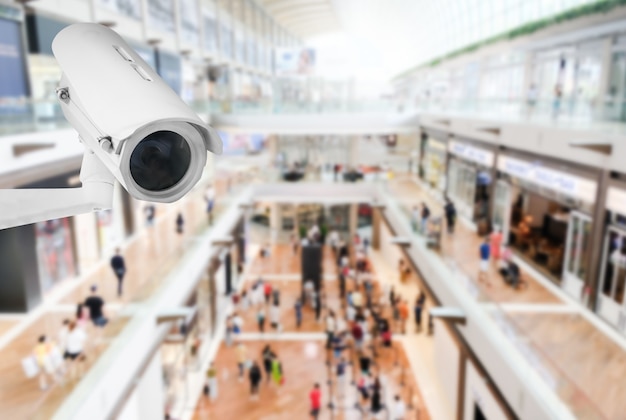 Caméra de vidéosurveillance publique moderne avec arrière-plan flou de centre commercial intérieur avec espace de copie