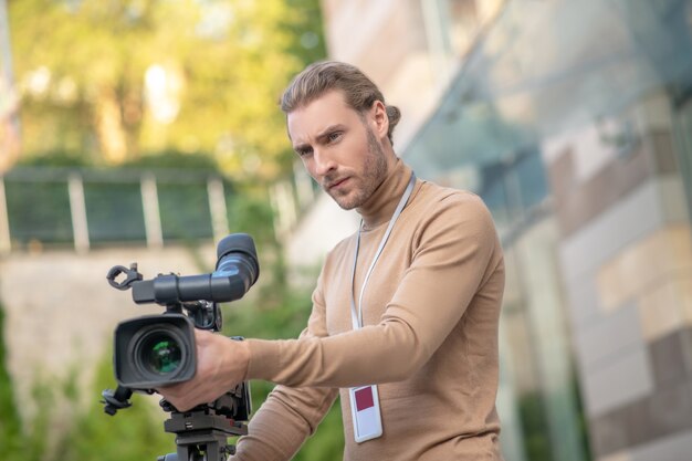 Caméraman installant l'appareil photo sur un trépied