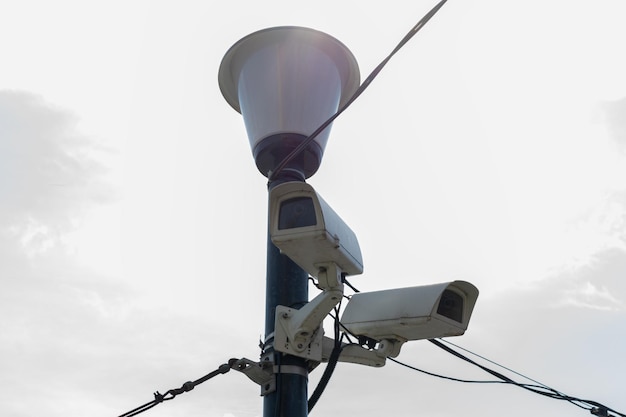 Caméras de surveillance montées sur un lampadaire contre une caméra de vidéosurveillance de sécurité à ciel bleu Sécurité dans la ville Filmage caché de ce qui se passe Technologies et équipements modernes