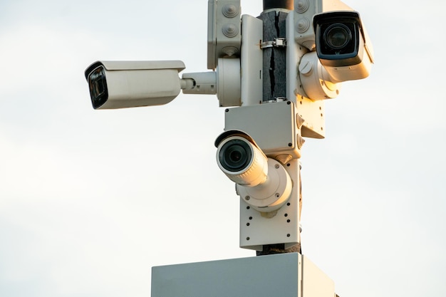 Caméras de vidéosurveillance dans un boîtier de protection blanc sur un lampadaire Caméra de vidéosurveillance extérieure installée dans les rues de la ville pour la sécurité de vos biens et de votre famille