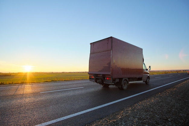 Camion cargo roulant sur l'autoroute transportant des marchandises en soirée. Concept de transport et de logistique de livraison.