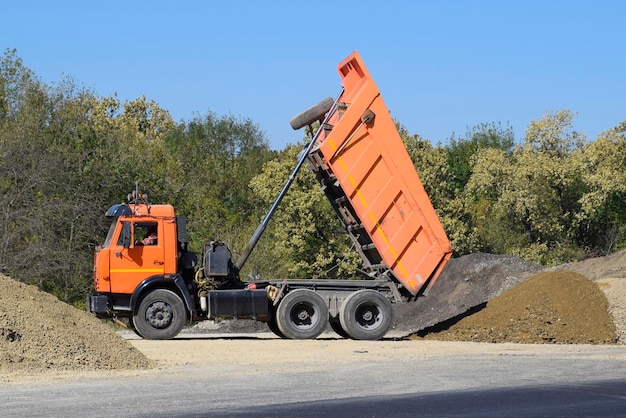 Le camion de décharge décharge les décombres Le camion décharge la cargaison Sable et gravier Construction de routes