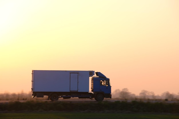 Camion de fret roulant sur l'autoroute transportant des marchandises en soirée Concept de transport et de logistique de livraison