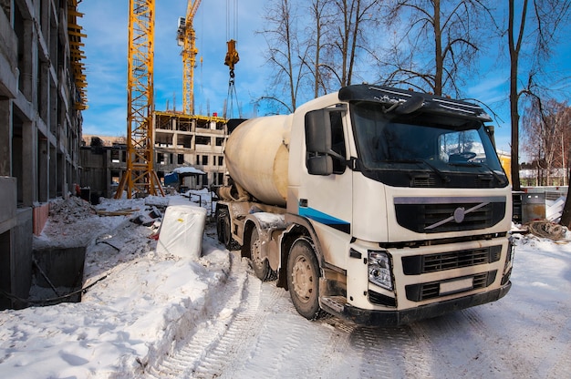 Camion malaxeur à béton se dresse sur le chantier de construction en hiver