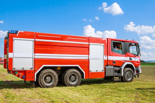 Camion de pompiers sur un champ sous un ciel bleu. Les sauveteurs.