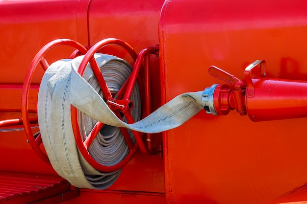 Camion de pompiers avec lance à incendie. Vue latérale du camion de pompiers municipal rouge au ralenti.