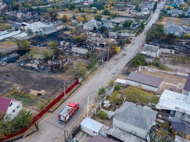 Un camion de pompiers se trouve dans le village détruit après un incendie Photo aérienne