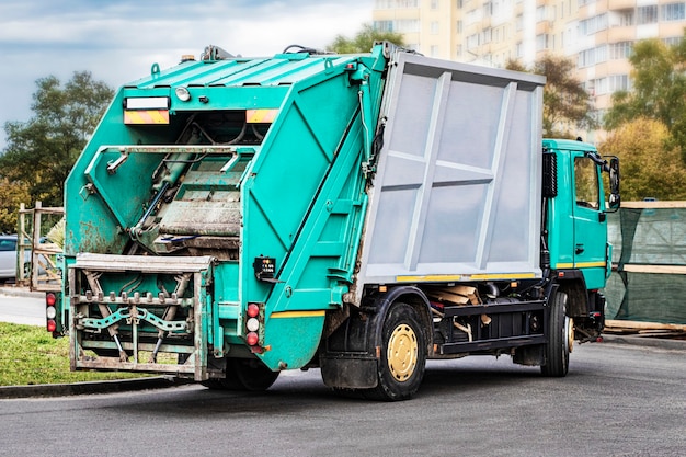 Un camion poubelle ramasse les ordures dans un quartier résidentiel. Collecte et élimination séparées des ordures. Véhicule de ramassage des ordures ménagères.