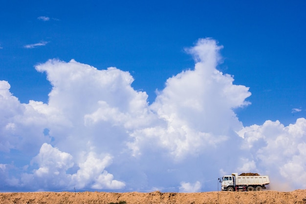 Le camion qui roule sur le sol de sable le ciel en arrière-plan