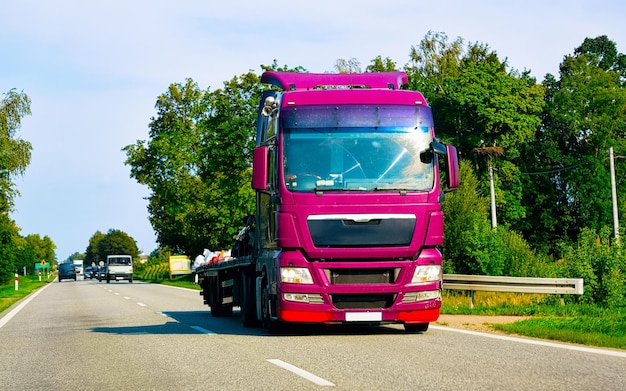 Camion vide sur la route d'été de la Pologne. Camionneur sur autoroute. Camion effectuant des travaux de logistique. Semi remorque avec chauffeur. Grand lecteur de voiture de fret. Livraison de fret. Industrie des transports à l'exportation. Conteneur avec des marchandises