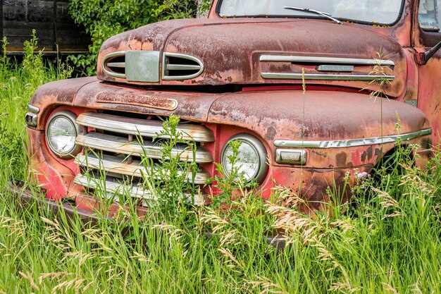 Camionnette rouge classique abandonnée dans les hautes herbes des prairies canadiennes