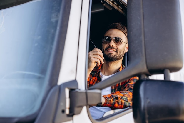 Camionneur homme assis dans une cabine et utilisant un émetteur radio