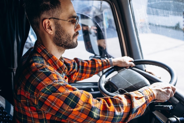 Camionneur homme conduisant dans une cabine de son camion