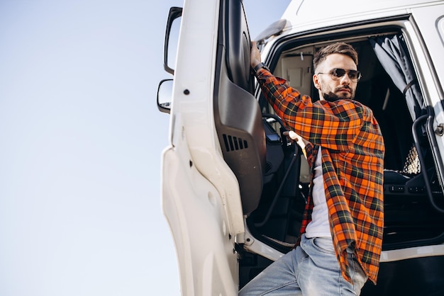 Camionneur homme heureux debout près de son camion