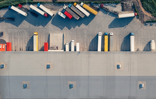 Les camions avec remorques sont chargés et déchargés dans le terminal de fret le matin top vu airive shot...