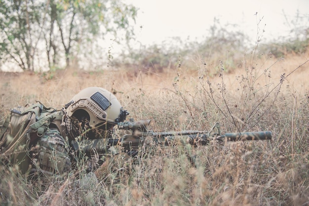 Camouflage militaire pour trouver des opportunités de tirer sur les ennemis dans le concept de guerre Grasssoldier