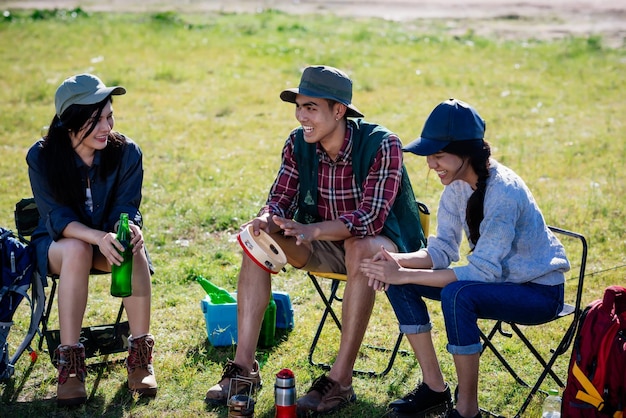 Camp de camping dans la nature des amis heureux assis discutent ensemble en été dans la forêt naturelle