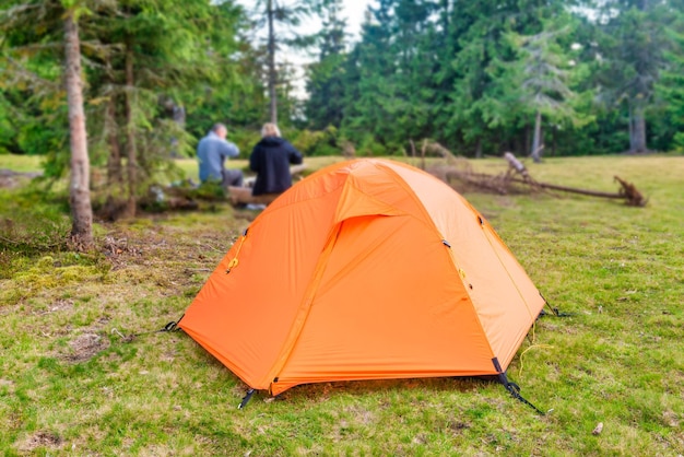 Camp de tente orange dans la forêt verte