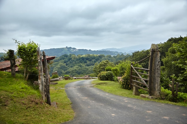 Photo campagne en france dans les contreforts des montagnes clôture en bois avec porte et route rurale