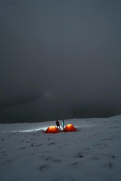 Camping au sommet d'une montagne enneigée brumeuse