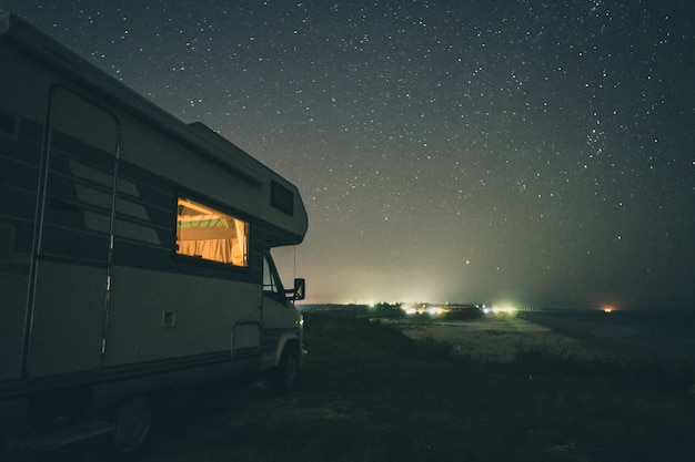 Camping avec camping-car en bord de mer. Paysage de nuit.