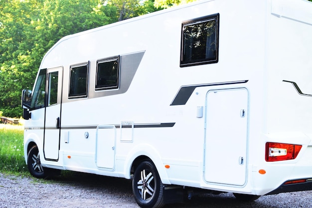 Un camping-car blanc avec une vitre noire sur le côté.