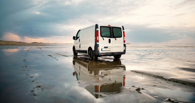 Camping-car roulant à côté de la mer des Wadden à marée basse, voyageant sur la plage de Romo au Danemark