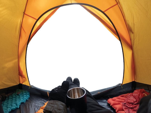 Camping avec la main tenant la tasse dans la tente jaune ouverte sur fond blanc