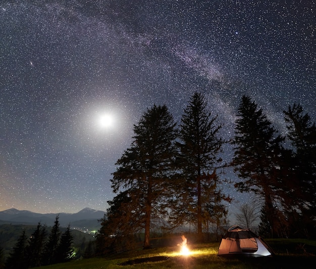 Camping nocturne en montagne sous ciel étoilé et voie lactée