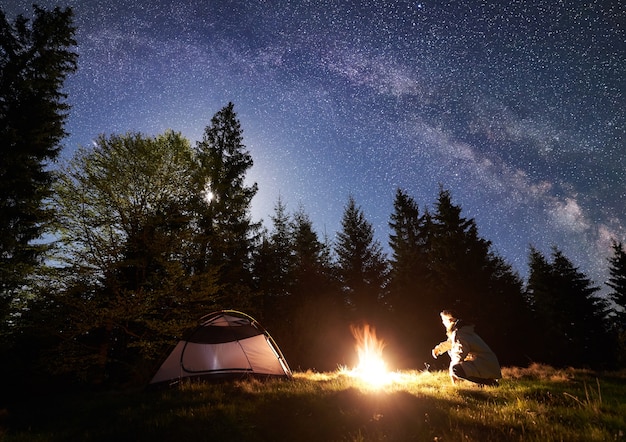 Camping nocturne en montagne sous ciel étoilé et voie lactée