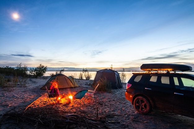 Camping touristique au bord de la rivière au coucher du soleil