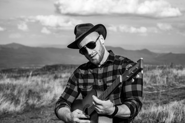 Photo camping vacances jeune homme voyageur avec guitare se détendre en plein air avec des montagnes pendant les vacances d'été l