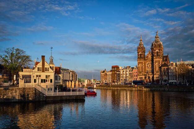 Canal d'Amsterdam et église Saint-Nicolas au coucher du soleil