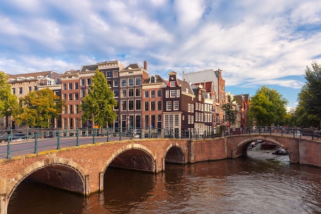 Canal d'Amsterdam Reguliersgracht avec maisons hollandaises typiques, pont et péniches pendant le matin ensoleillé, Hollande, Pays-Bas.