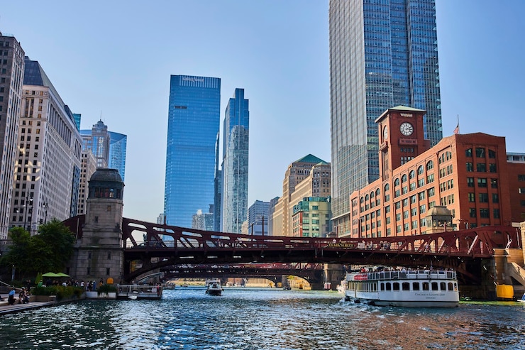 Photo canal de chicago avec des bateaux de tourisme sous des ponts rouges avec des gratte-ciel bleus et des immeubles de bureaux d'été