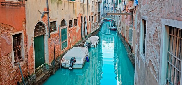 Canal vert avec des bateaux à Venise Italie