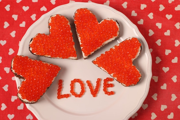 Canape au caviar rouge et fromage à la crème en forme de coeur pour la Saint Valentin. Vue d'en-haut