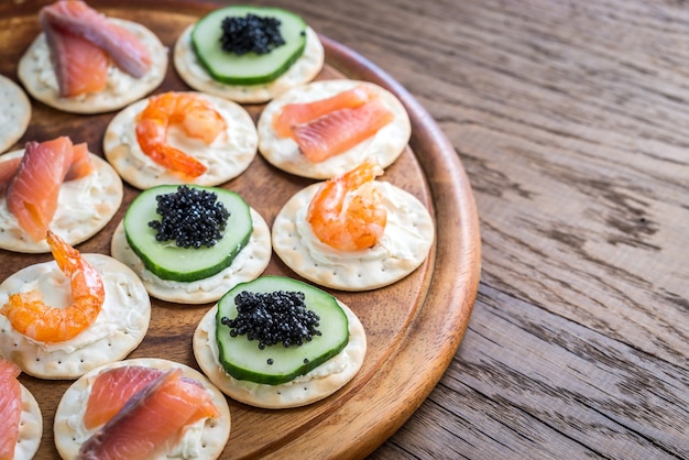 Canape aux fruits de mer sur la planche de bois