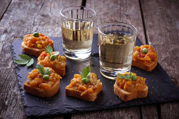 Canape avec caviar d&#39;aubergines et verres de vin. Mise au point sélective