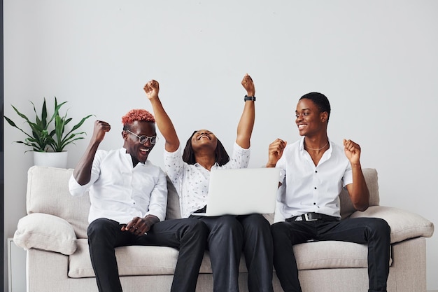 Canapé confortable à l'aide d'un ordinateur portable Groupe d'hommes d'affaires afro-américains travaillant assis ensemble