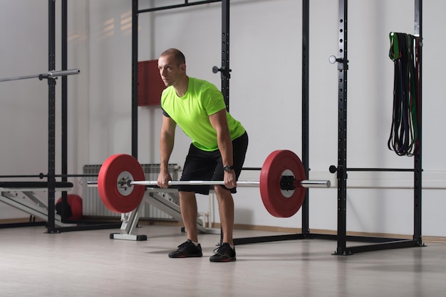 Canapé faisant des exercices de poids lourds pour le dos avec des haltères dans la salle de sport