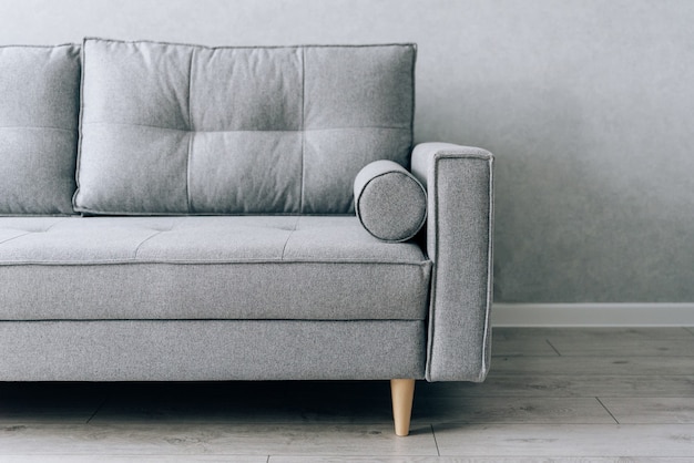 Canapé gris moderne avec pieds en bois dans la chambre