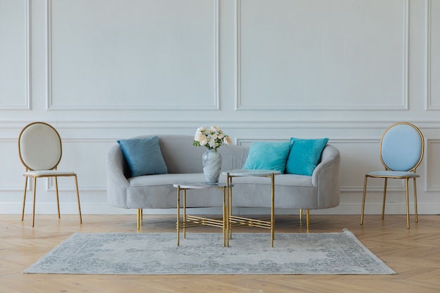 Canapé léger et chaises contre un mur blanc