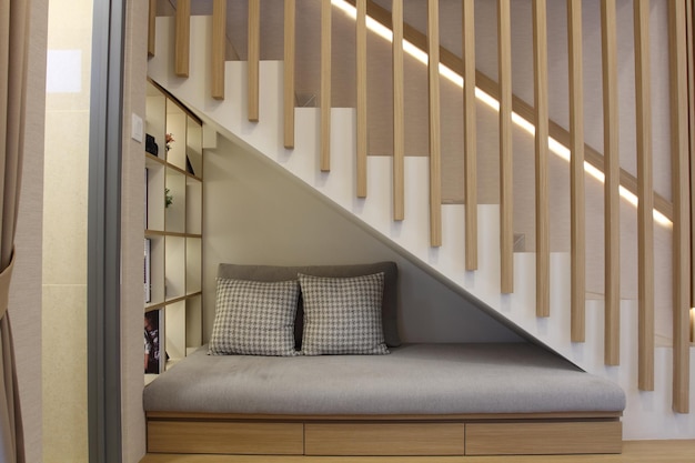 Le canapé avec quelques oreillers sous l'escalier Design d'intérieur moderne