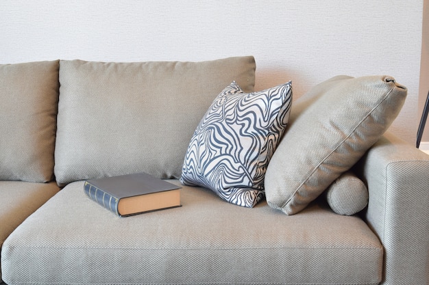 Canapé en velours confortable avec coussins à rayures grises dans le salon moderne