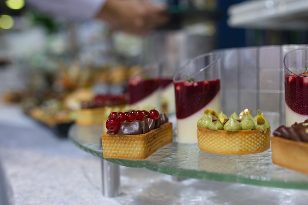 Des canapes et des desserts colorés et délicieux sur une étagère en verre lors d'un événement de restauration